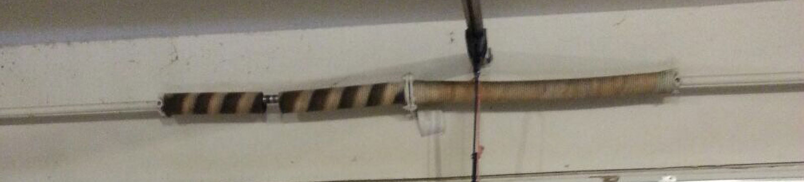 Broken torsion spring visible on sectional garage door in Colleyville home