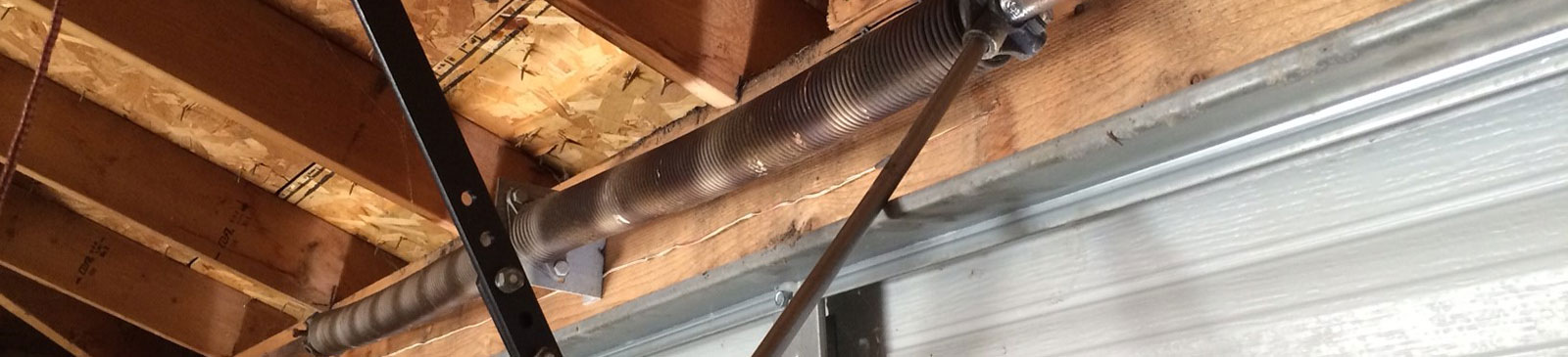 Expert technician installing replacement lift cables on residential garage door